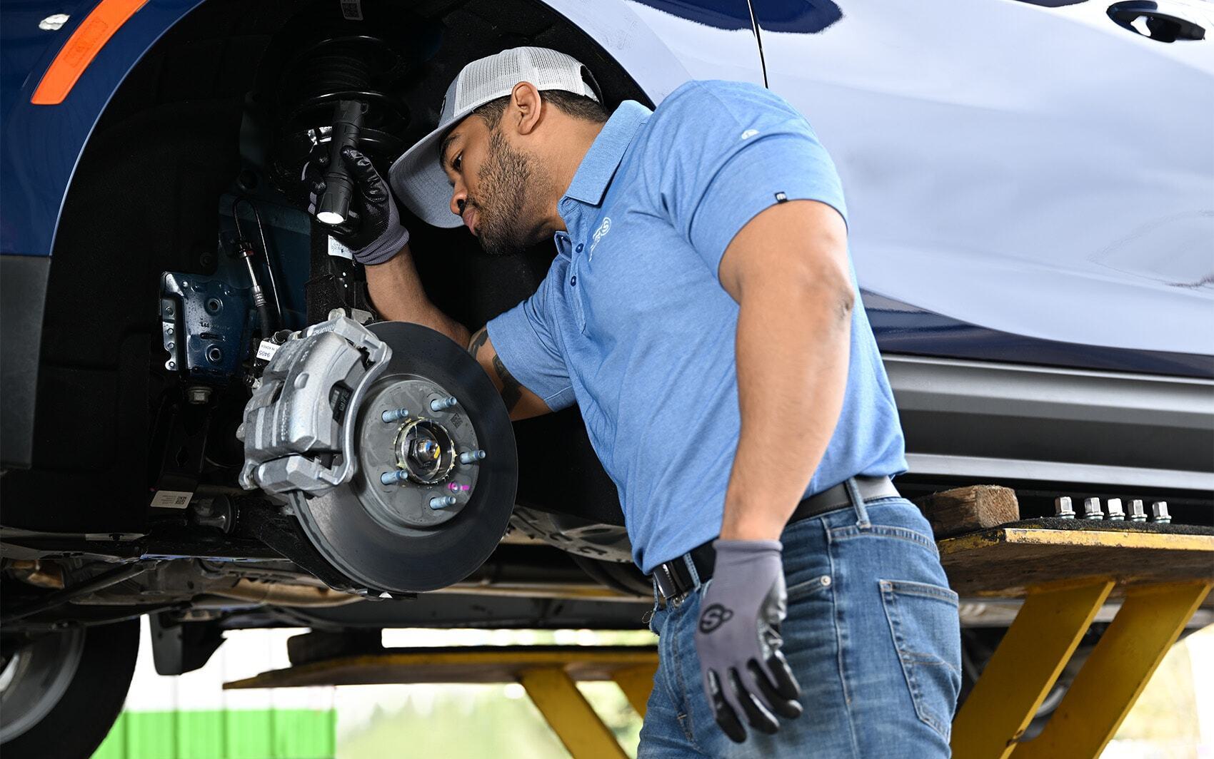 Brakes technician inspecting brake system 1